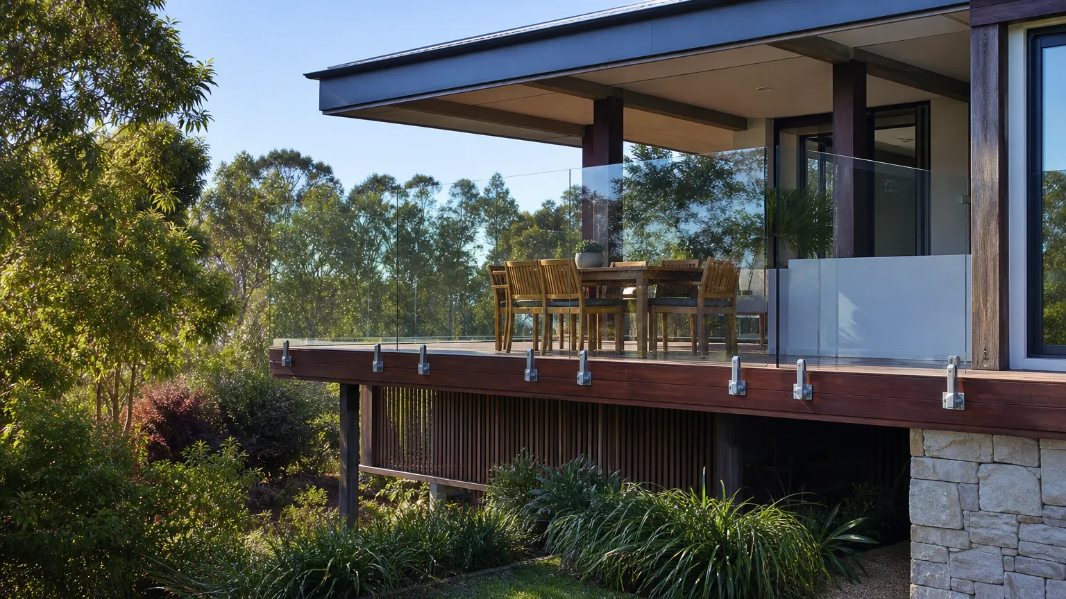a frameless glass balustrade on side-mounted spigots along a raised timber deck
